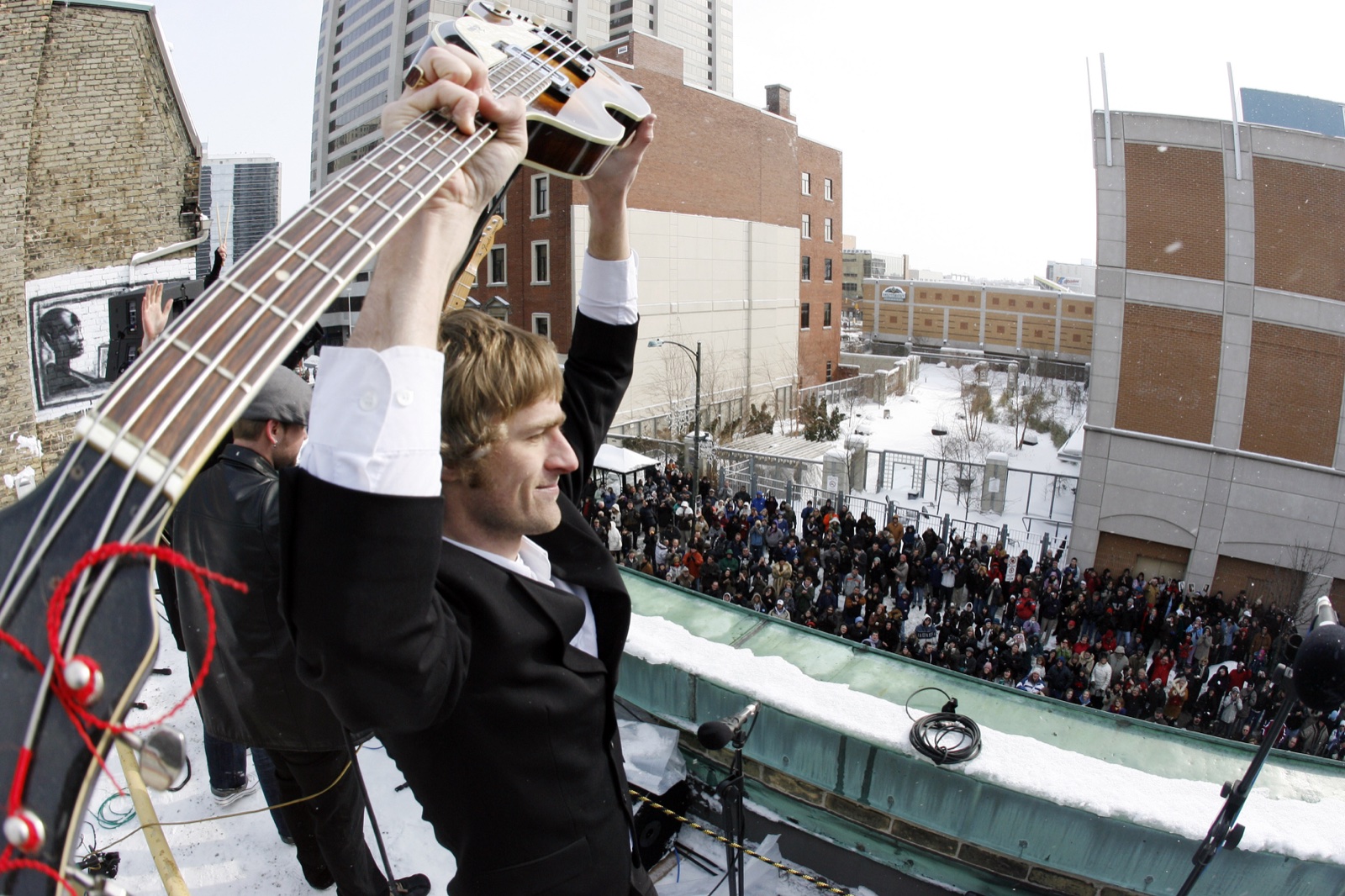 Yuri raising his bass above a snowy crowd during the 2009 rooftop concert